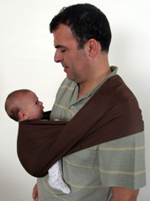 Ο μπαμπάς και το νεογέννητο μωρό του κοιτάζονται στα μάτια σε μάρσιπο αγκαλιάς Αστεράκι