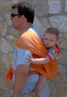 Ο μπαμπάς φοράει το μωρό του στην πλάτη με μάρσιπο wrap